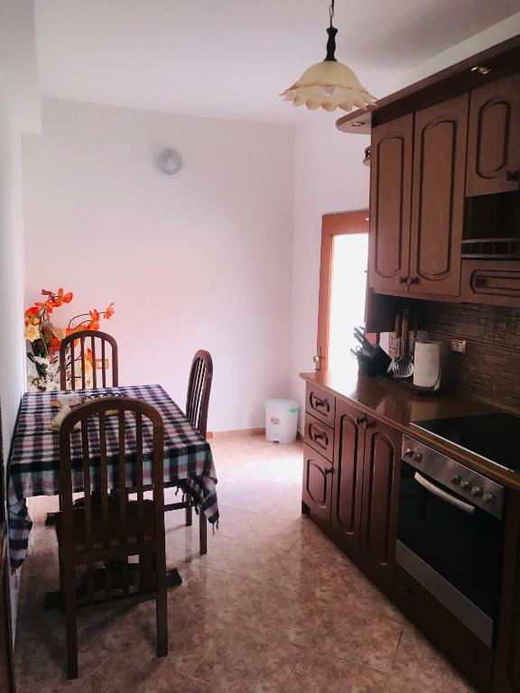 a kitchen with a table and a table and chairs at Jemin Apartment in Berat