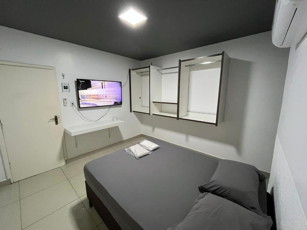 Habitación pequeña con cama y TV. en Pousada Torre Forte, en Bujari