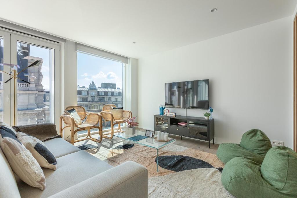 a living room with a couch and a tv at Sweet Inn - De Brouckere in Brussels