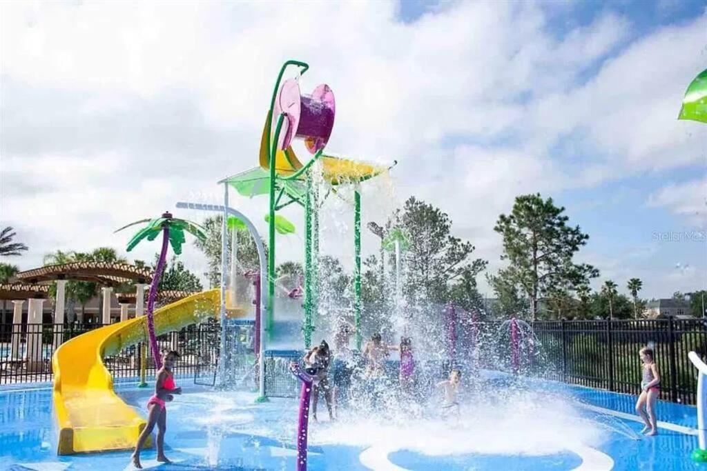 Un parque acuático con gente jugando en una fuente. en Minutes to Disney, Free Water Park & Private Pool, en Orlando
