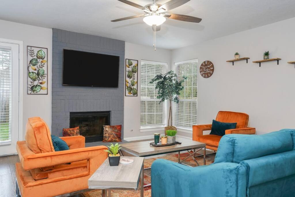 uma sala de estar com mobiliário laranja e azul e uma televisão de ecrã plano em IDYLLIC LAKEVIEW HOME em Spring