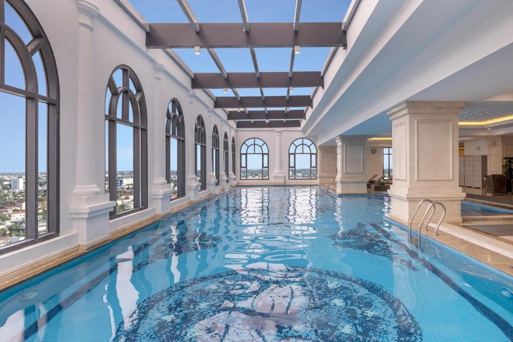 a swimming pool in a building with windows at Meliá Vinpearl Phu Ly in Phủ Lý