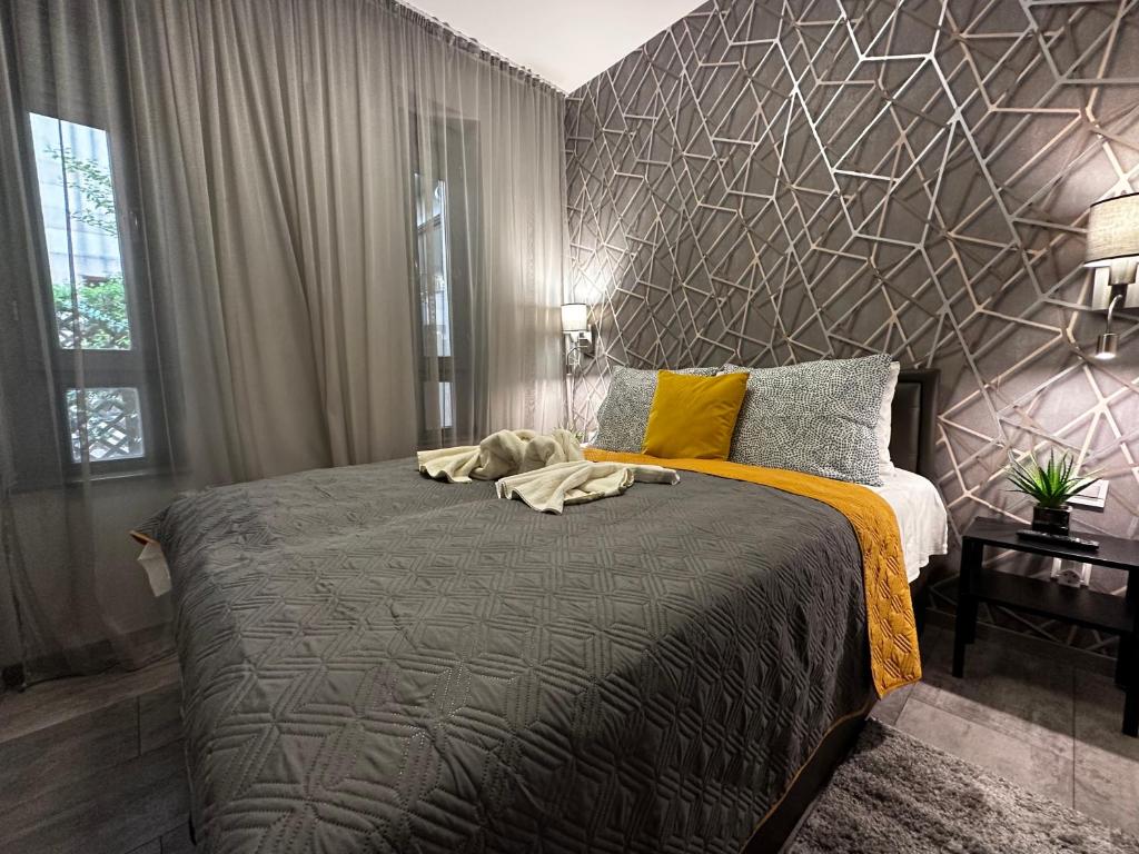 a bedroom with a large bed with a geometric wall at King Apartments in Budapest