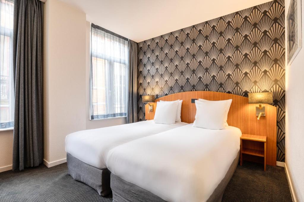 Postel nebo postele na pokoji v ubytování Aris Grand Place Hotel