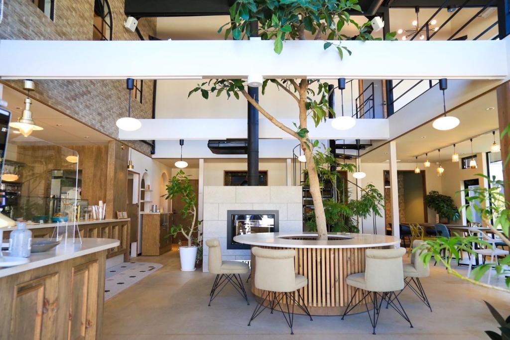 restauracja ze stołem, krzesłami i drzewem w obiekcie KIIIYA cafe&hostel w mieście Azumino