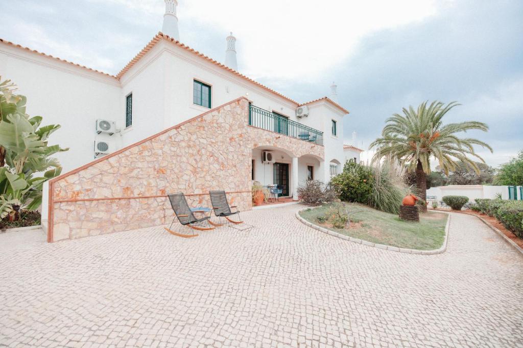 a house with two chairs in front of it at Casa Velha Apartments - Adults friendly in Albufeira