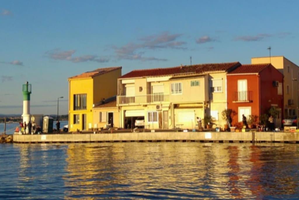 un groupe de bâtiments à côté d'une masse d'eau dans l'établissement Jolie maison de pêcheur - La Pointe Courte, à Sète