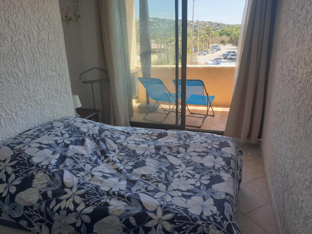 sypialnia z łóżkiem i widokiem na balkon w obiekcie 3 pièces face mer et St-Tropez w mieście Cogolin