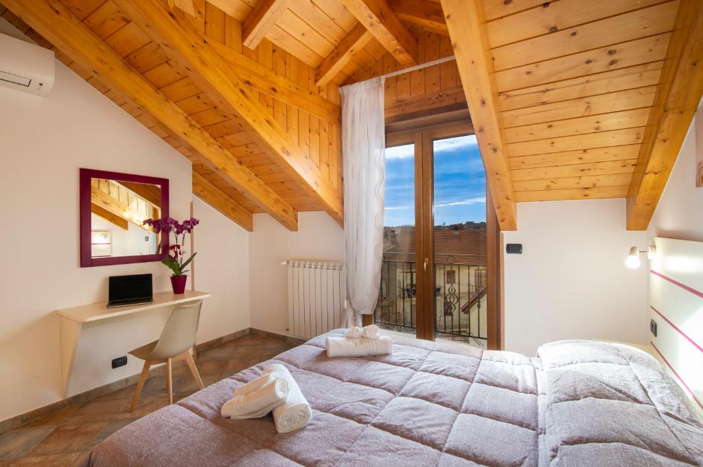 a bedroom with a large bed and a desk at Hakuna Matata tra sentieri in Agerola