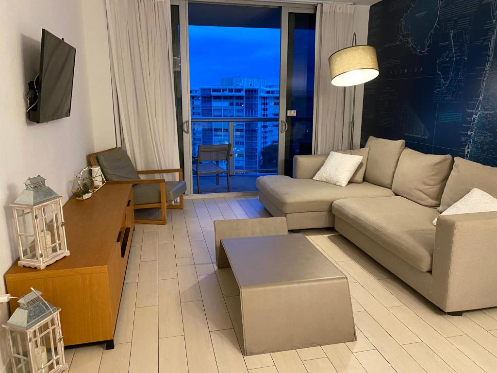 a living room with a couch and a table at Designer Beachfront Apartment Views, Luxury & Full Kitchen 805 A in Hallandale Beach