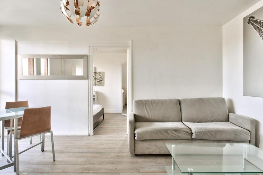 een woonkamer met een bank en een tafel bij Charming flat with balcony at the doors of Paris - Welkeys in La Courneuve