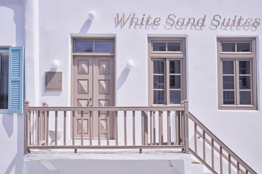 a white house with a balcony and a white sand suite at White Sand Suites Mykonos in Mikonos