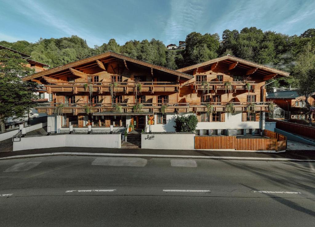 a large wooden building with a street in front of it at TheResi Appartements in Saalbach Hinterglemm