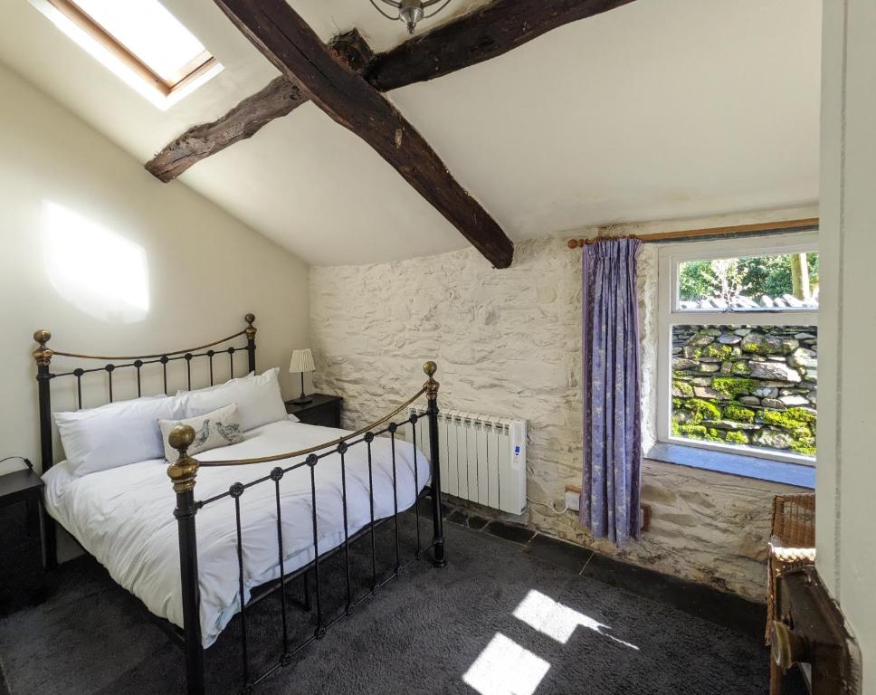 a bedroom with a bed and a window at Millers Cottage, Broughton - family & pet friendly in Broughton in Furness