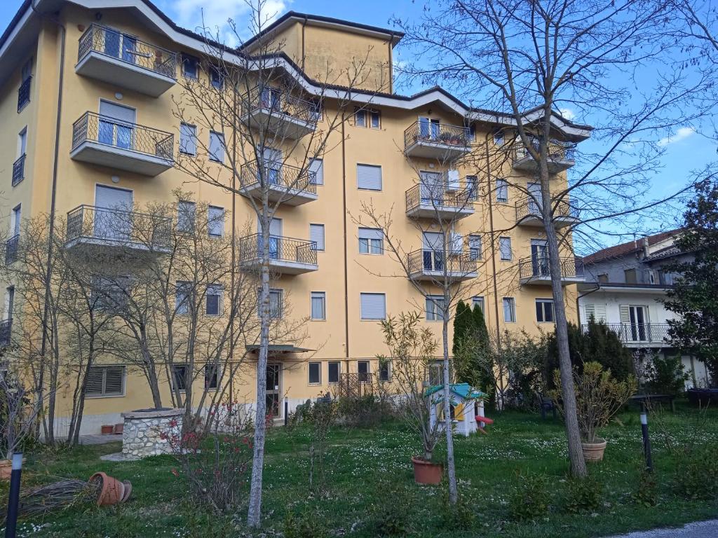 un grande edificio giallo con balconi di Hotel Aquila a Scoppito