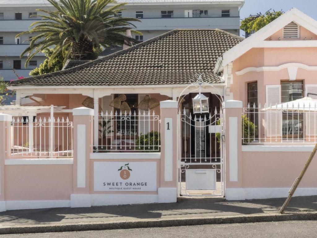 una casa rosa con una puerta delante en Sweet Orange Guest House, en Ciudad del Cabo