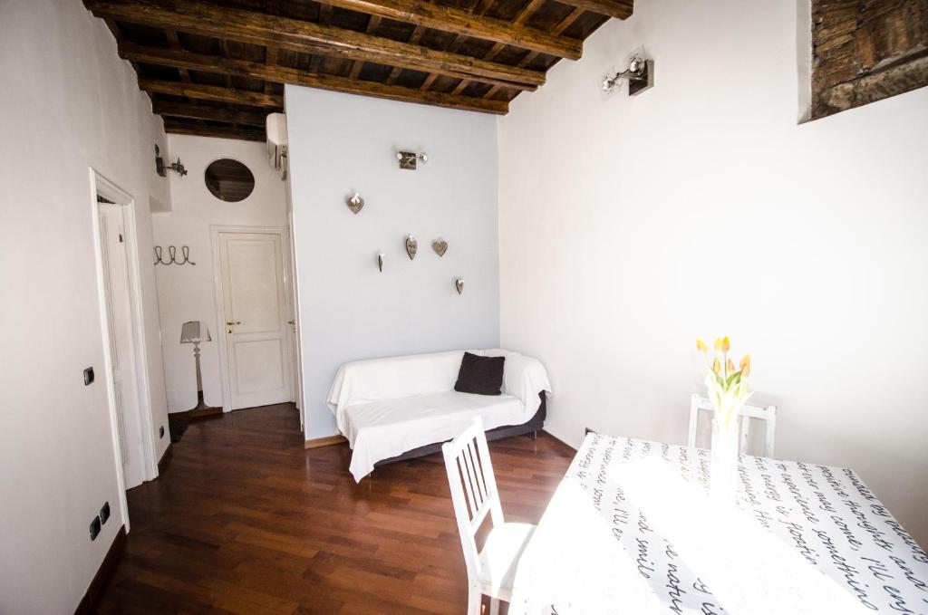 um quarto branco com uma mesa e um sofá em Scent Of Trastevere em Roma