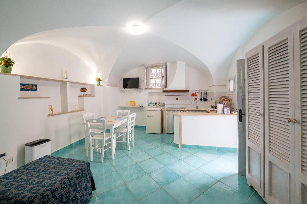 Divina Casa Vacanze في سبرلونغا: مطبخ مع طاولة وكراسي في غرفة