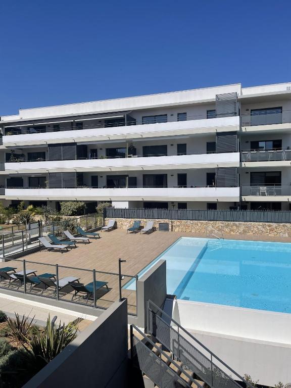 een extern uitzicht op een gebouw met een zwembad bij Très bel appartement dans résidence avec piscine à 5min des plages de Villeneuve Loubet. in Villeneuve-Loubet