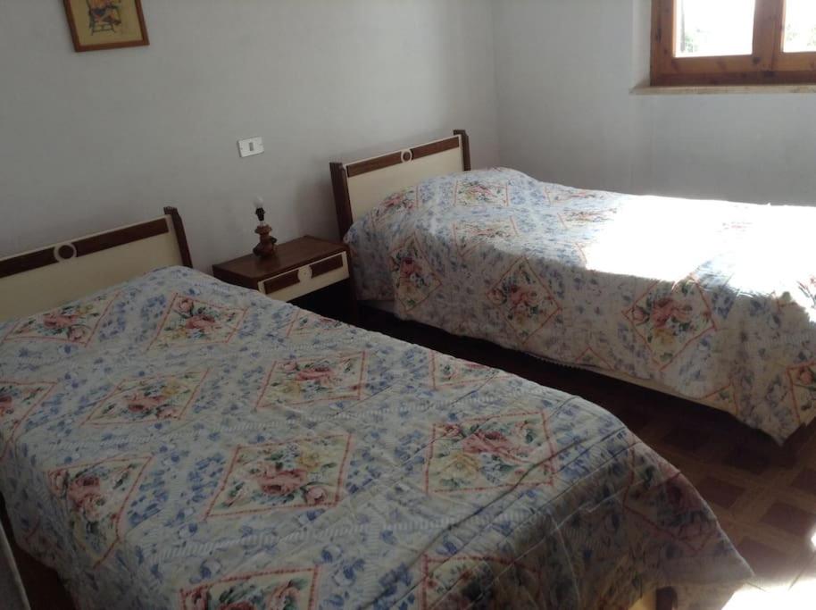 a bedroom with two beds and two night stands at Casa Alessandra in Pomonte