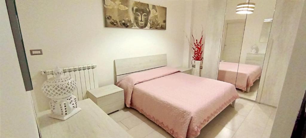 um quarto com uma cama rosa e um espelho em Il gingillo di Alice em Letojanni