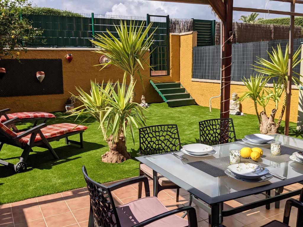 een patio met een tafel en stoelen in een tuin bij Apartamento Sarah in Miami Platja