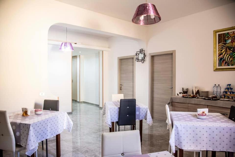 a restaurant with two tables and chairs and purple lights at Blu Mare Lampedusa Bed And Breakfast in Lampedusa