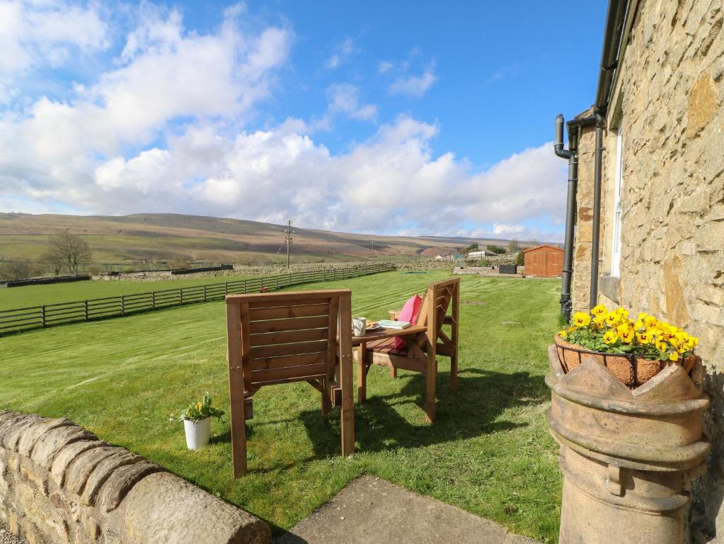 two chairs and a table in the grass next to a building at Hudeway View in Barnard Castle