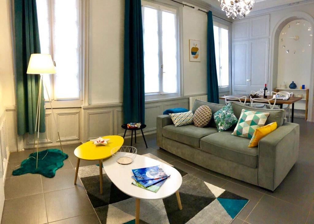 uma sala de estar com um sofá e uma mesa em La Loge d'Harcourt : Hypercentre chic et moderne em Rouen