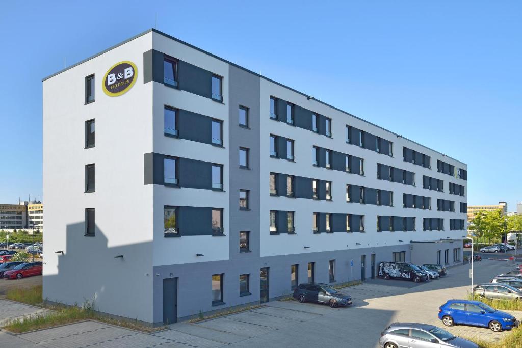 an apartment building with a parking lot at B&B Hotel Köln-Ehrenfeld in Cologne