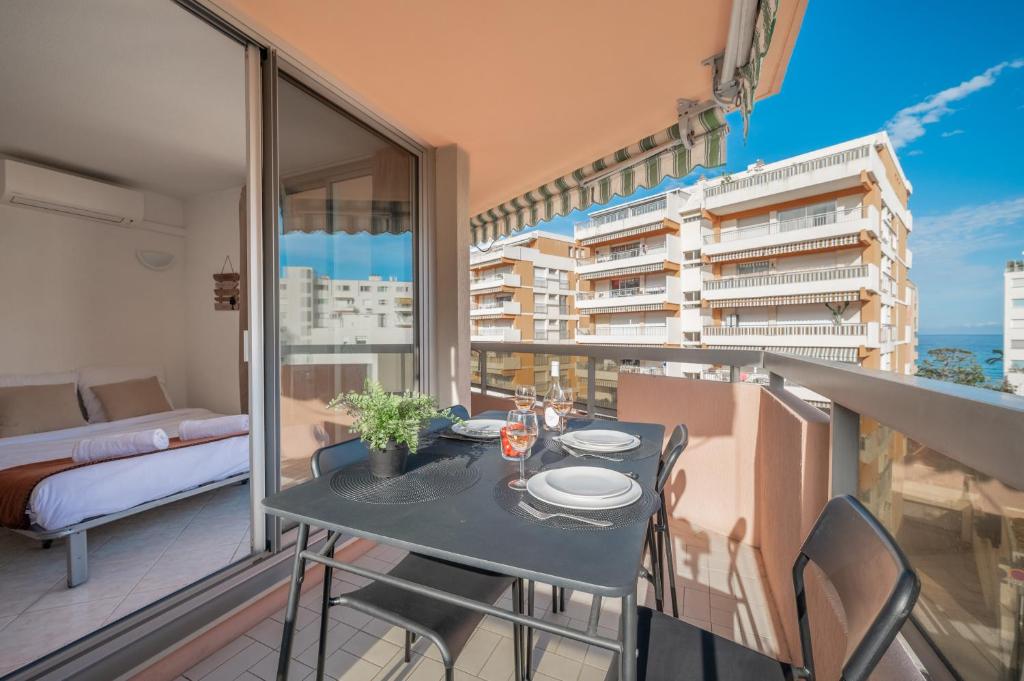 a balcony with a table and chairs and a bed at Appartement 4 pers à 50m de la plage, avec piscine in Roquebrune-Cap-Martin