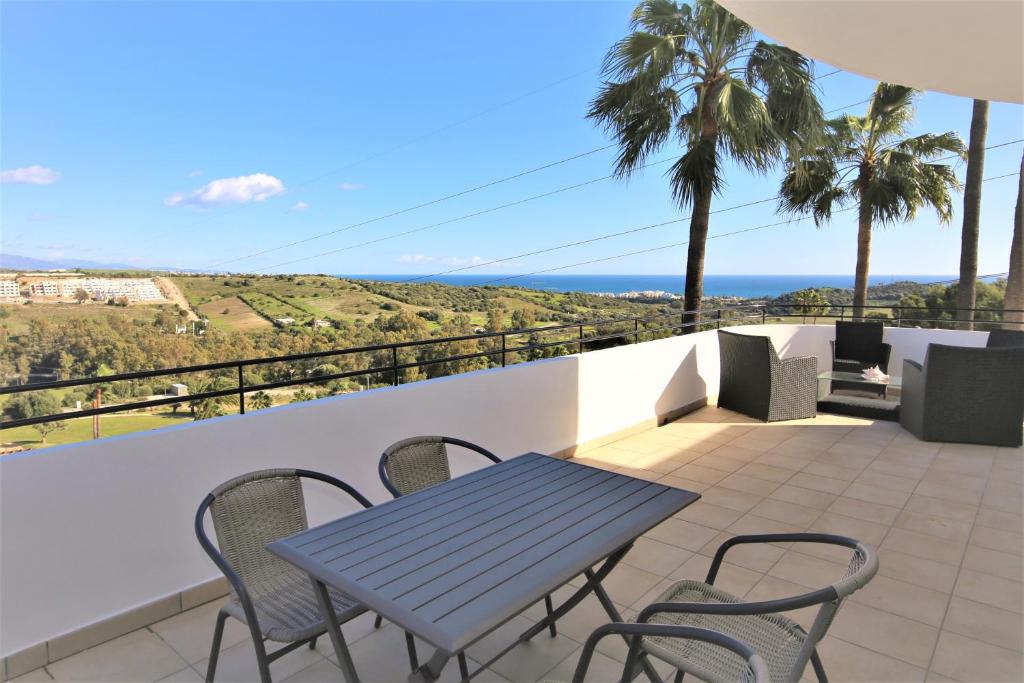 einen Tisch und Stühle auf einem Balkon mit Meerblick in der Unterkunft Apartment GENOA in Estepona