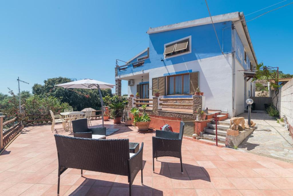 um pátio com cadeiras e uma casa azul em Monolocale grande em La Maddalena