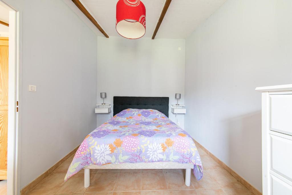 a bedroom with a bed with a comforter at Les Lavandes - Charmante maison avec terrasse in Pertuis