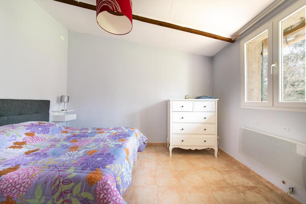 a bedroom with a bed and a dresser and a window at Les Lavandes - Charmante maison avec terrasse in Pertuis