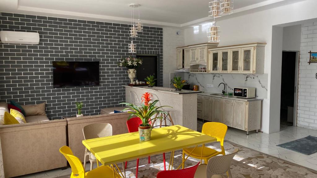 a kitchen and dining room with a yellow table and chairs at Duplex80 in Tashkent