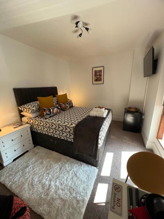 a bedroom with a bed and a dresser and a tv at Sailortown BED & BREAKFAST in Belfast