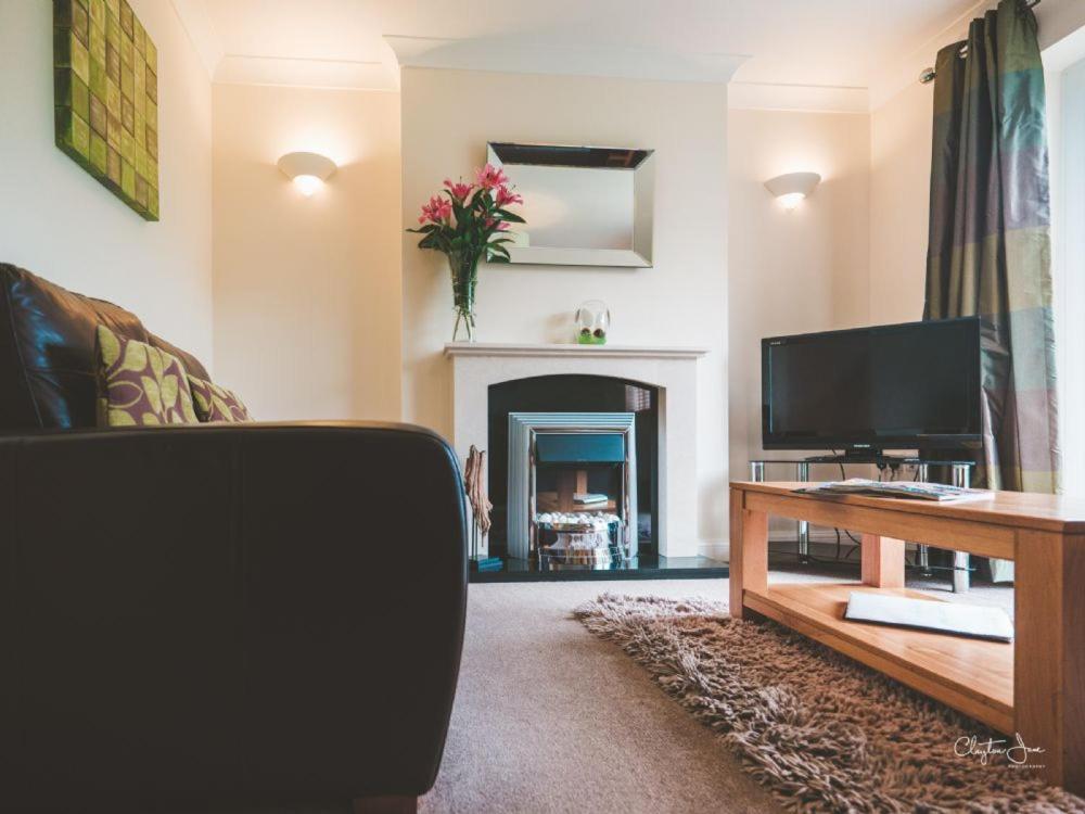 a living room with a television and a fireplace at Honeybee Cottage 15P in North Petherton