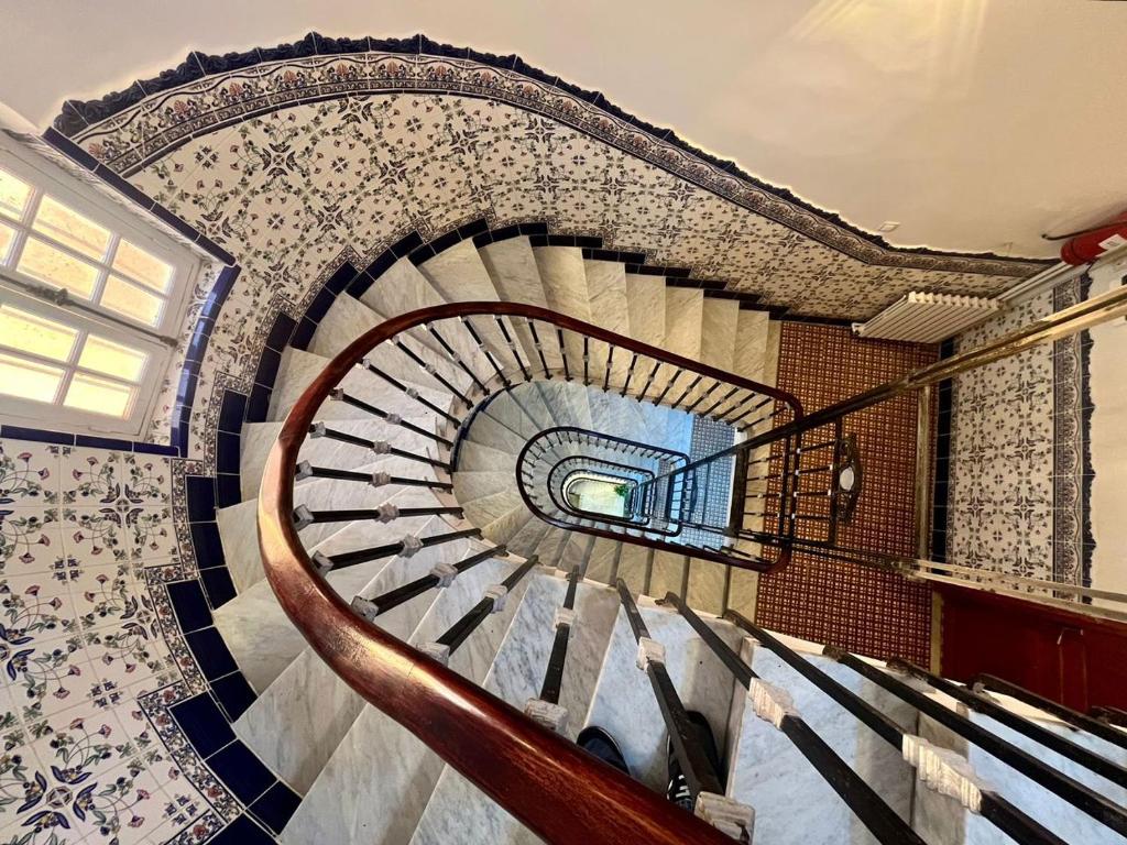 a spiral staircase in a building with a tile wall at AFRIC HOTEL- Casbah in Alger