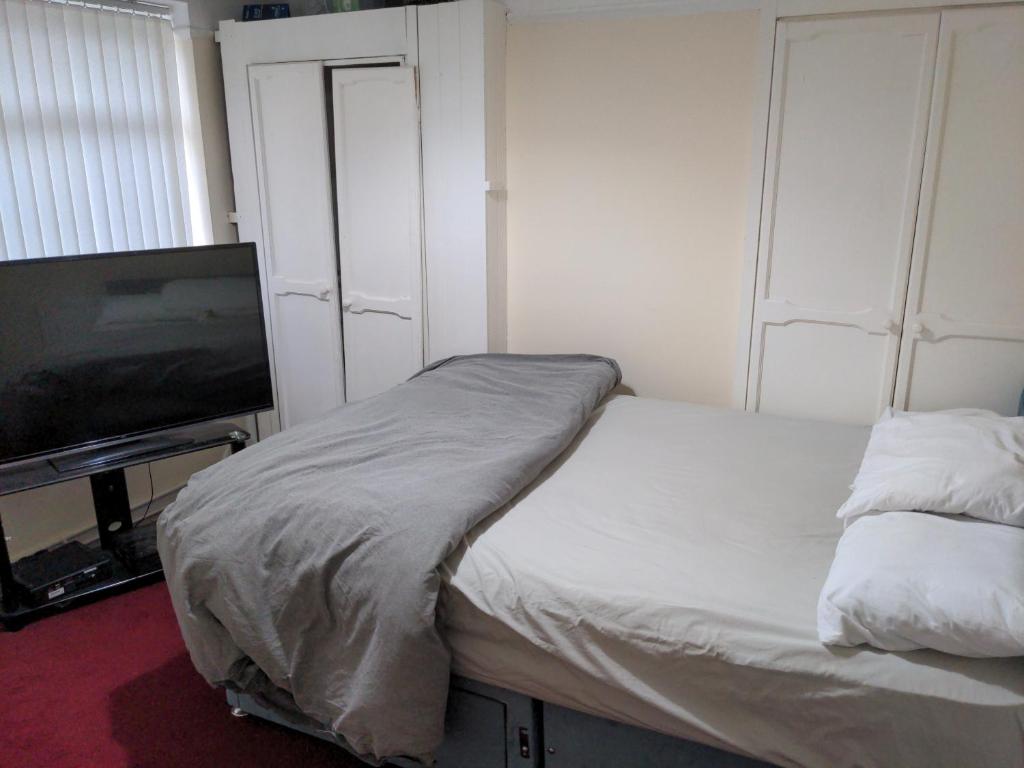 1 dormitorio con 1 cama y TV de pantalla plana en Liverpool, en Liverpool