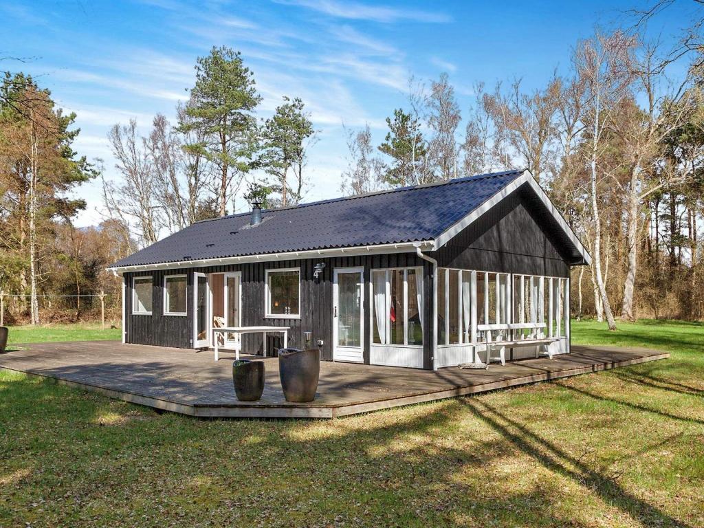 a small cabin with a deck in the grass at 2 person holiday home in L s in Læsø