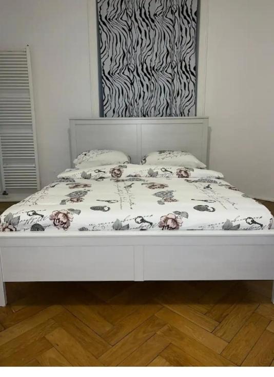 a white bed with a floral bedspread and pillows at Appartamento di Vacanze in Muralto