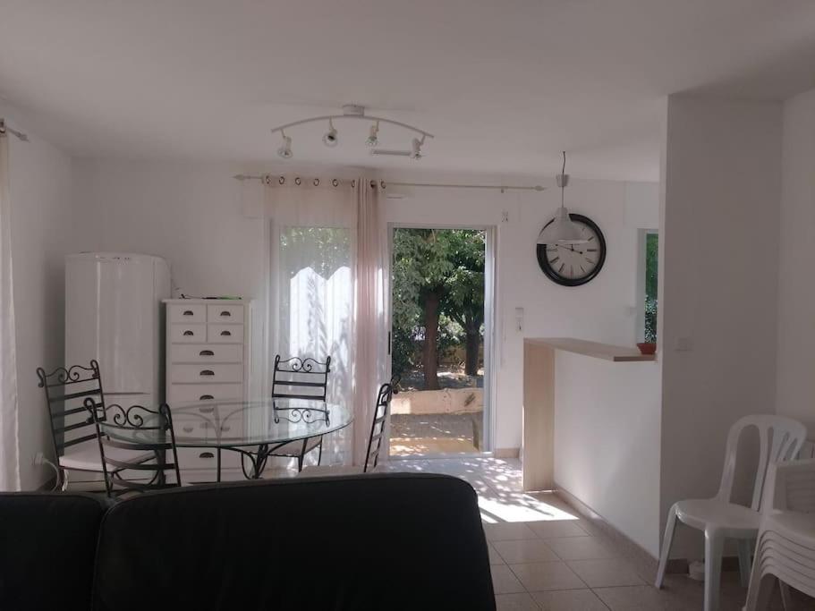 une cuisine et une salle à manger avec une table et des chaises en verre dans l'établissement Maison proche de la mer, au Barcarès