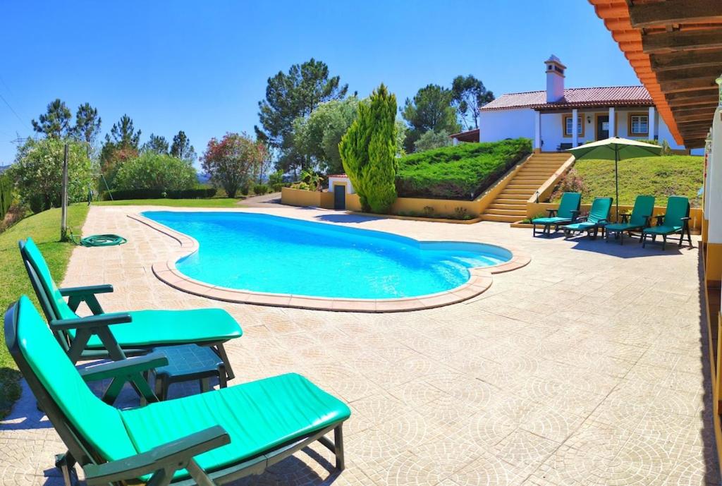 un patio con sillas y una piscina en Castelo de Bode Monte do Valinho Country house with private pool and panoramic views, en Alverangel