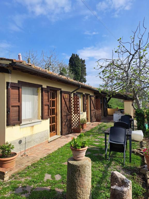 ein Haus mit einer Terrasse und Stühlen im Hof in der Unterkunft Agriturismo Fontevecchia in Vetulonia