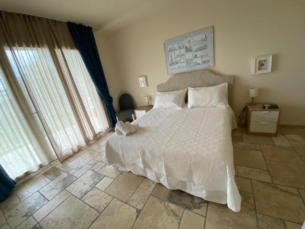 a bedroom with a large bed with white sheets and pillows at The Bee House in San Giovanni