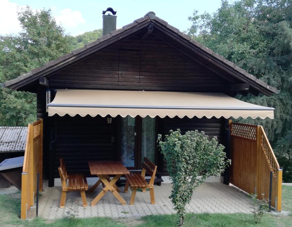 a cabin with a table and chairs in front of it at Ruhig gelegenes Ferienhaus in Simmelsdorf