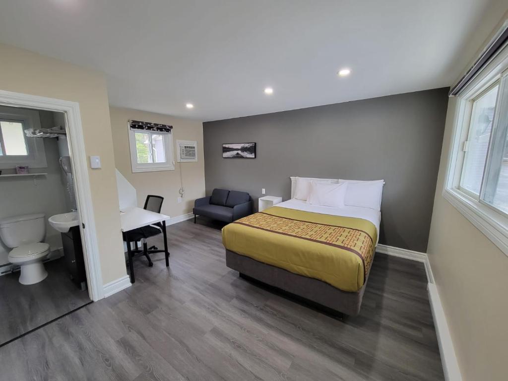 ein Hotelzimmer mit einem Bett und einem Schreibtisch in der Unterkunft Pine Motel in Deep River