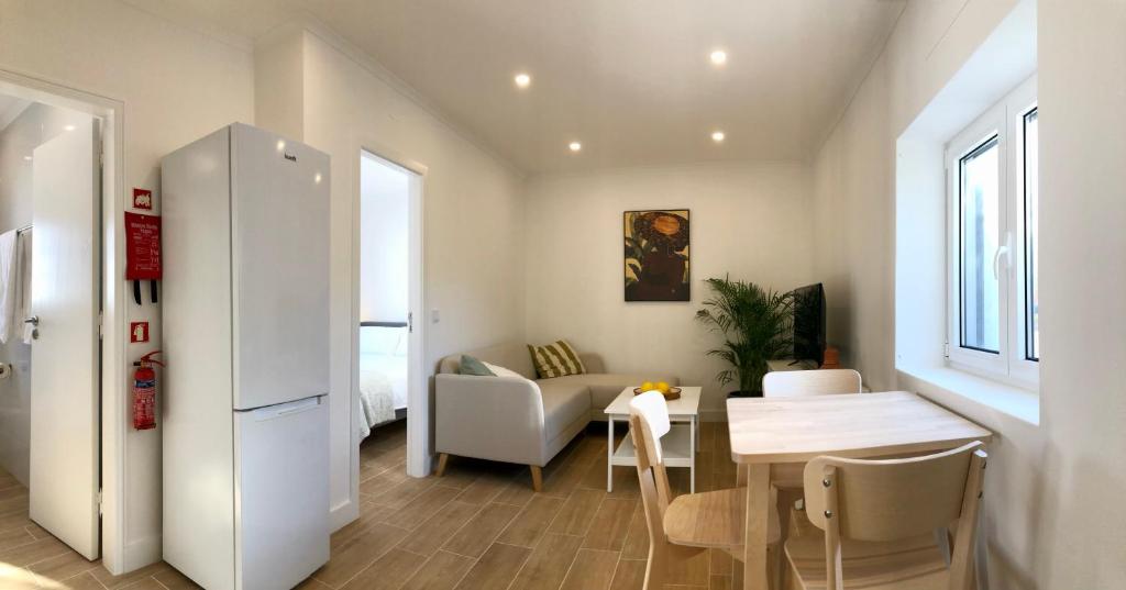 Casa Martins Country Apartment No5 في Freiria: غرفة معيشة مع طاولة وثلاجة بيضاء