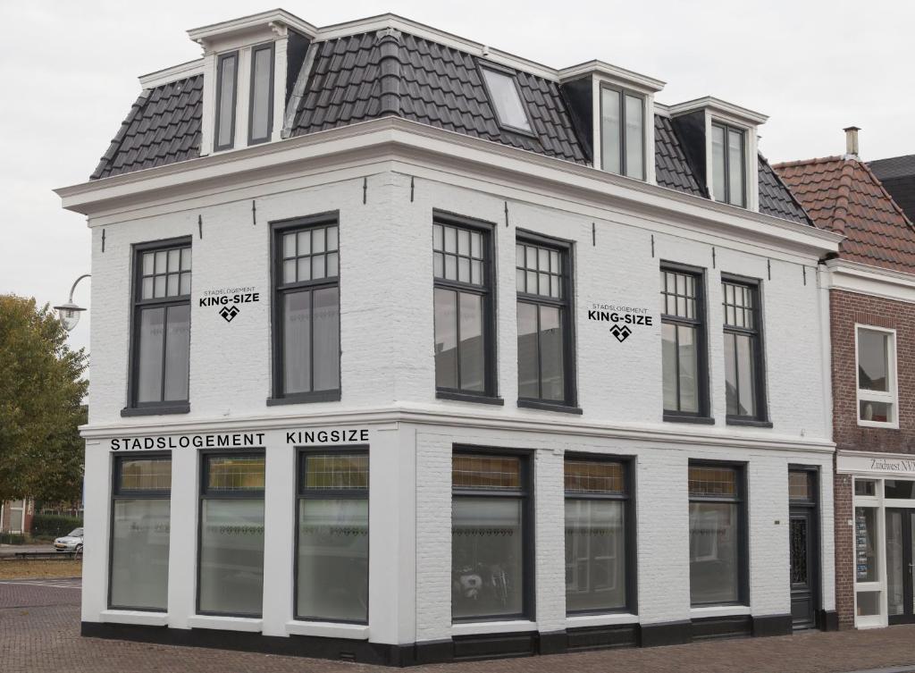 a white building with a black roof at Stadslogement Kingsize in Sneek